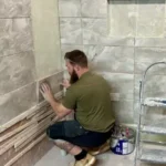 Person-fixing-a-wall-tile-546×478